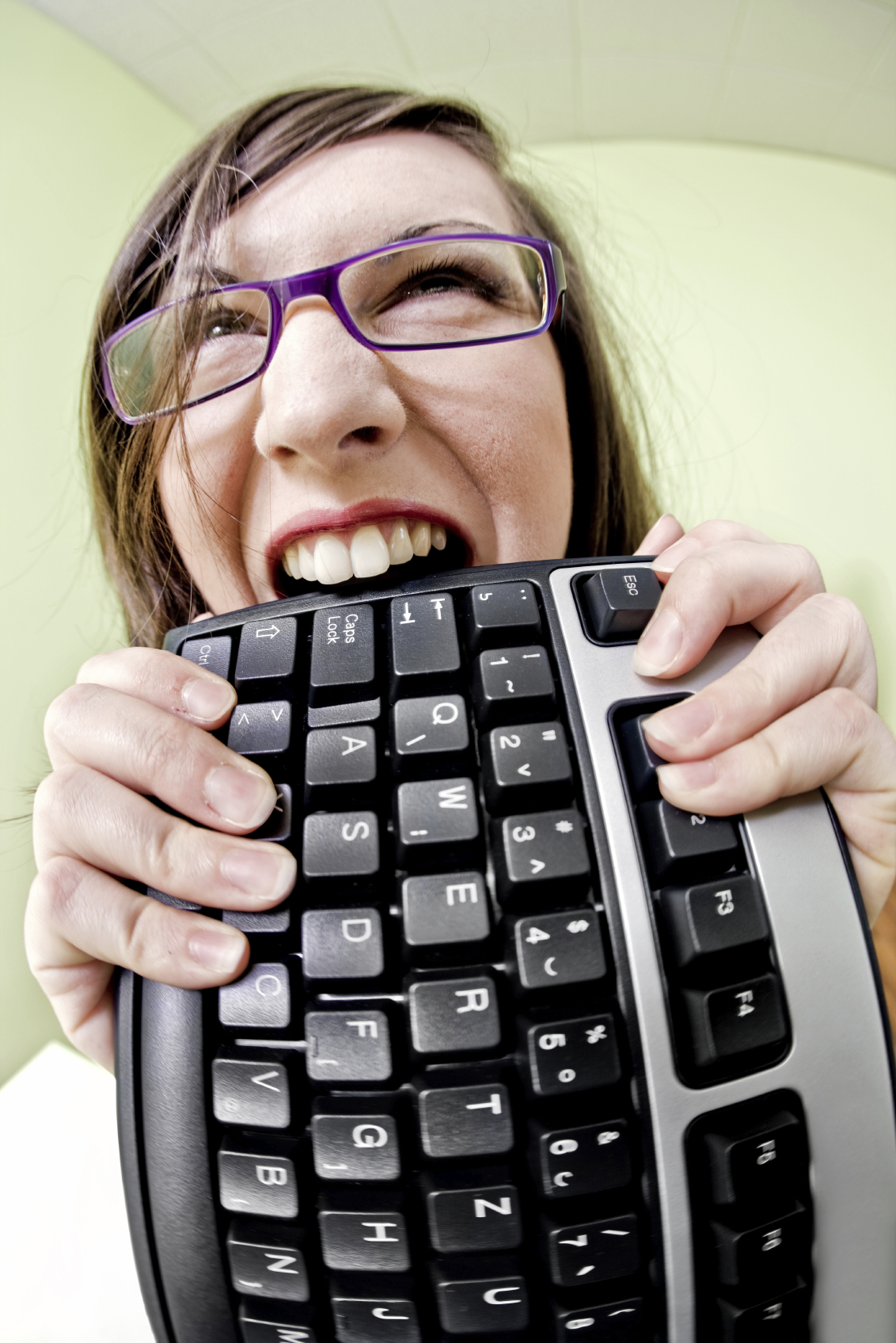 hatecomputer woman frustrated with computer and eating keyboard